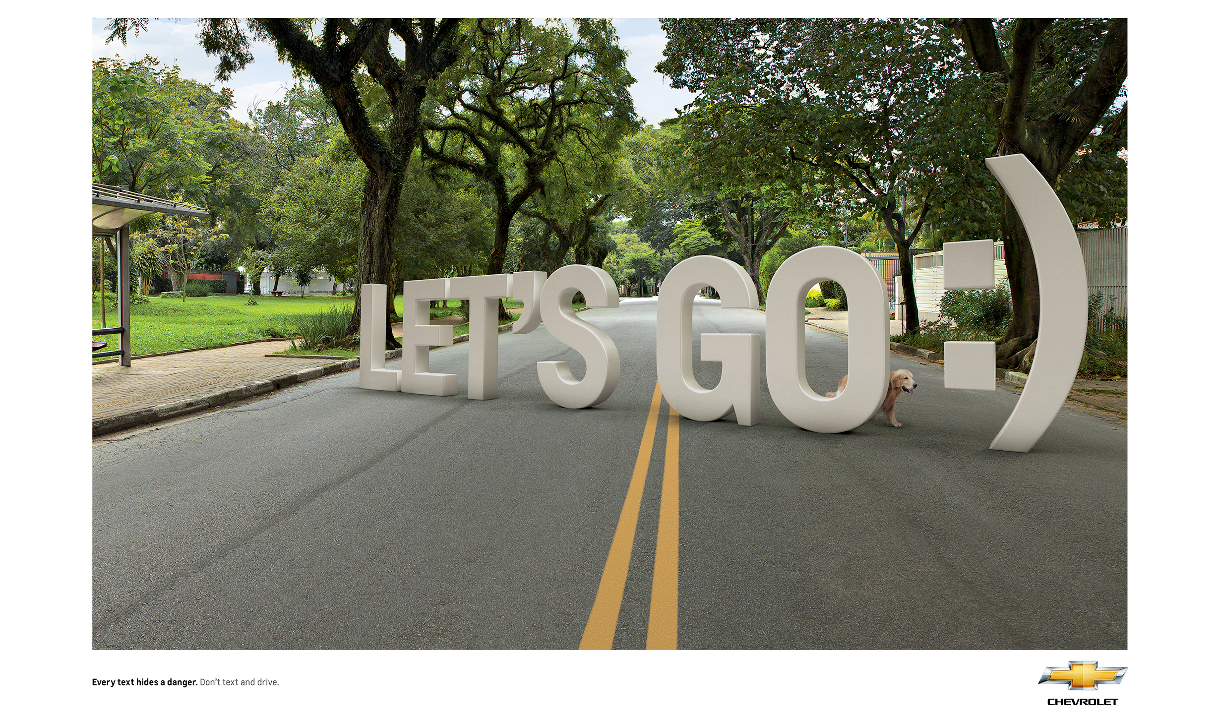 An empty street with a dog crossing. In front of the dog there are big letters saying 'Lets Go :)' hidding the dog. The text says 'Every text hides a danger. Don't text and drive'