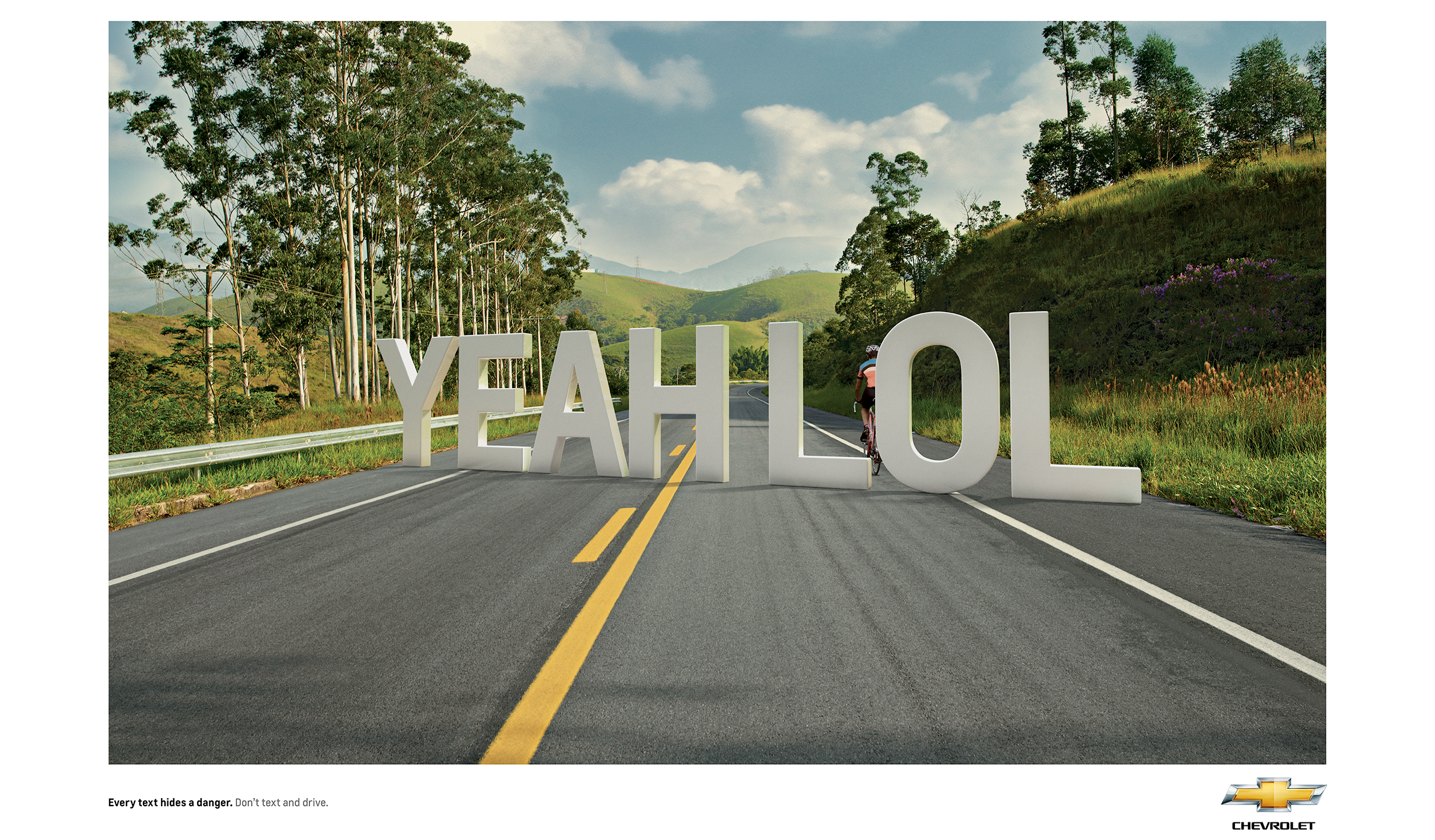 An empty road with a ciclist cicling on the right side. In front of the biker there are big letters saying 'Yeah LOL' hidding him. The text says 'Every text hides a danger. Don't text and drive'